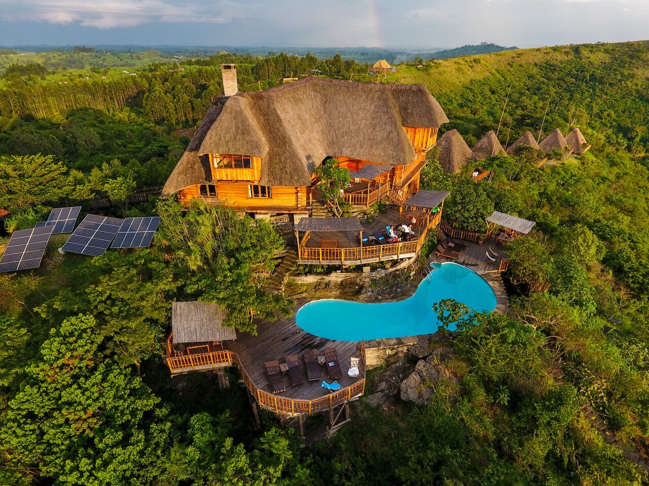 Eco lodge on a green hillside with pool and solar panels